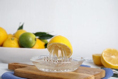 Photo of Glass squeezer and fresh lemon on wooden board