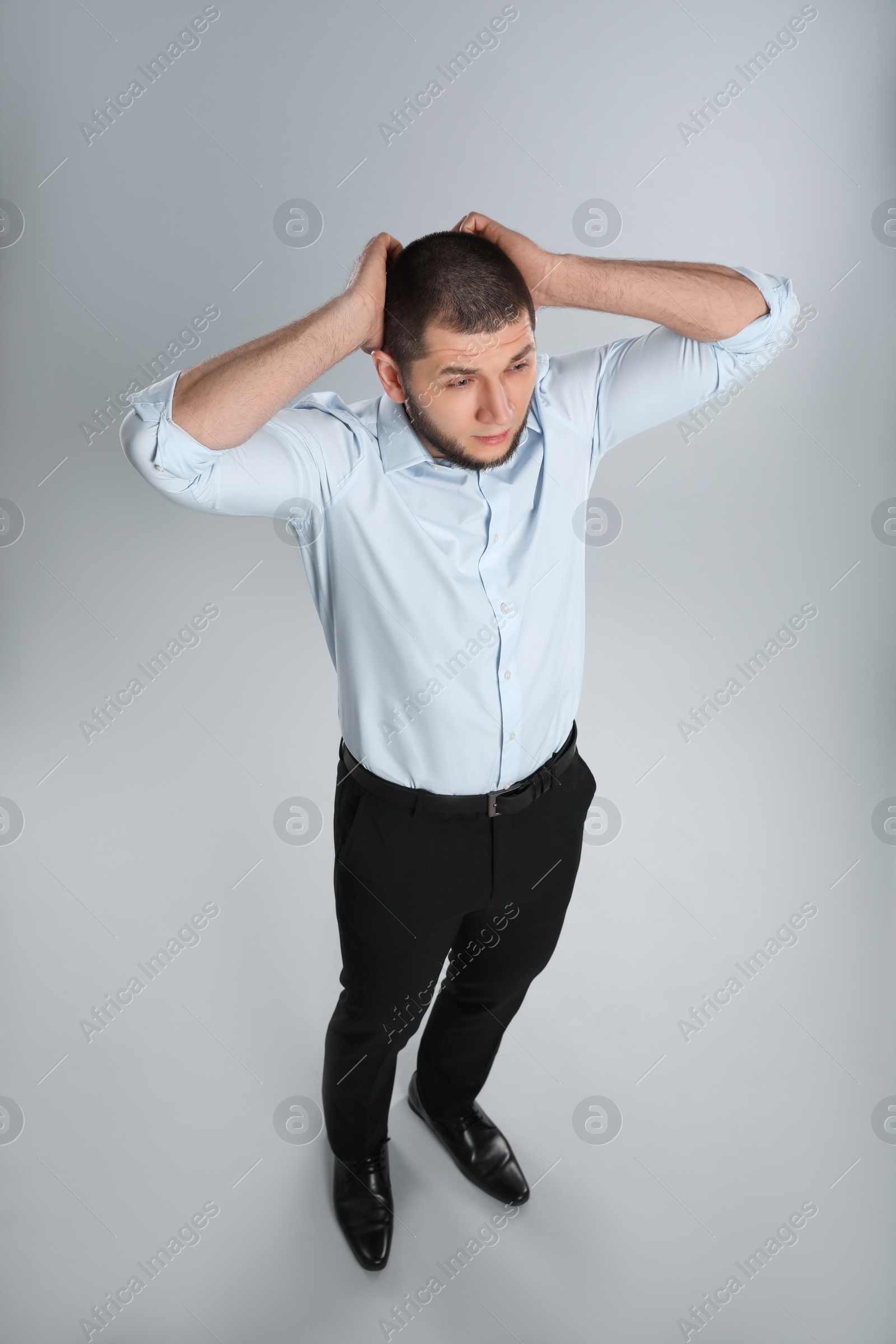 Photo of Emotional professional businessman on grey background, above view