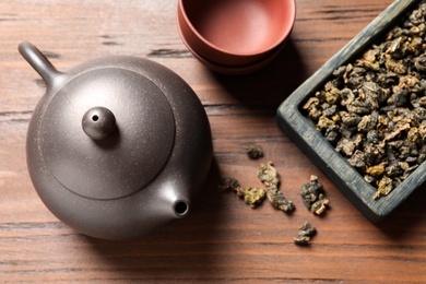 Photo of Flat lay composition with Tie Guan Yin oolong tea leaves on wooden table