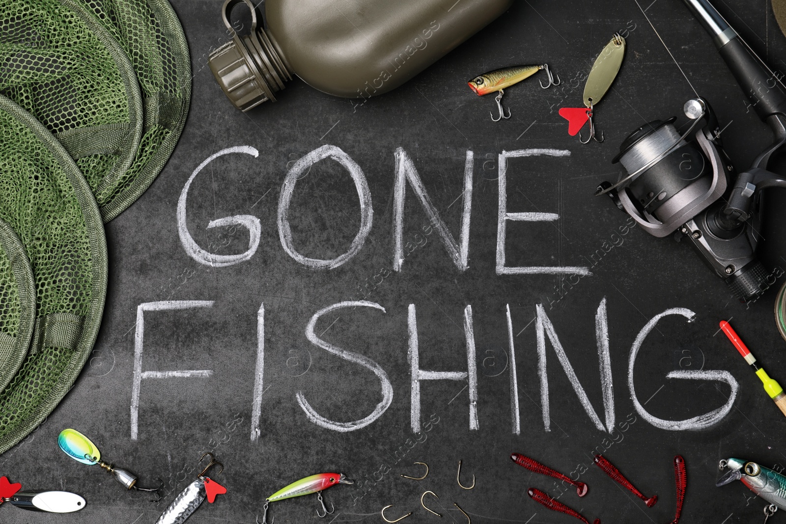 Photo of Flat lay composition with angling equipment and words "GONE FISHING" on dark background