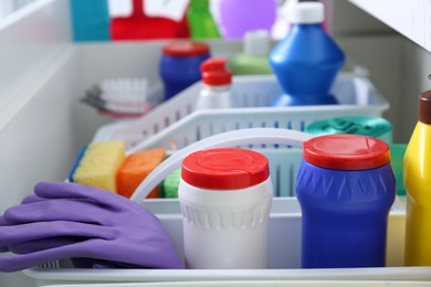 Photo of Different cleaning supplies in open drawer, closeup