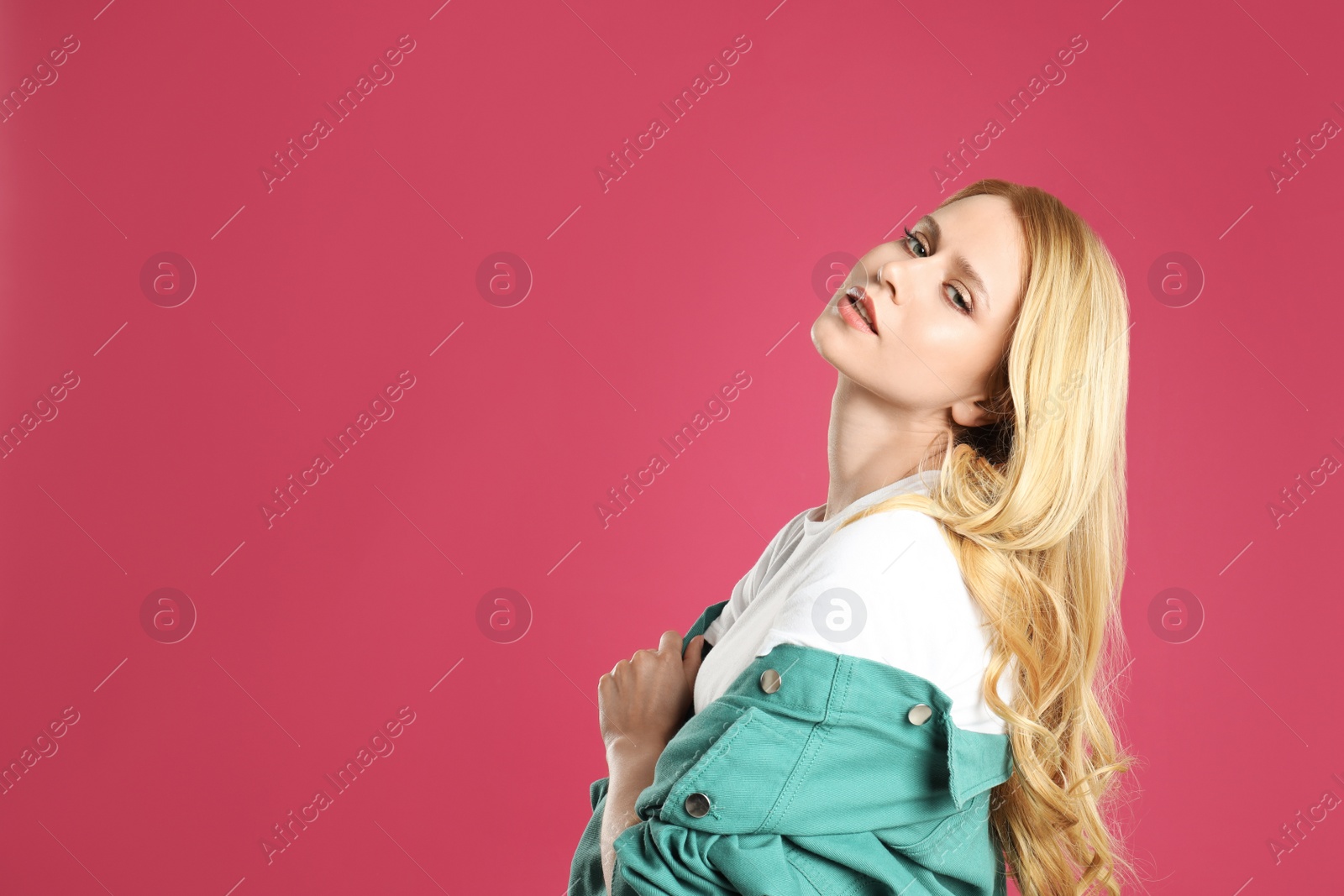 Photo of Portrait of beautiful young woman with dyed long hair on pink background. Space for text