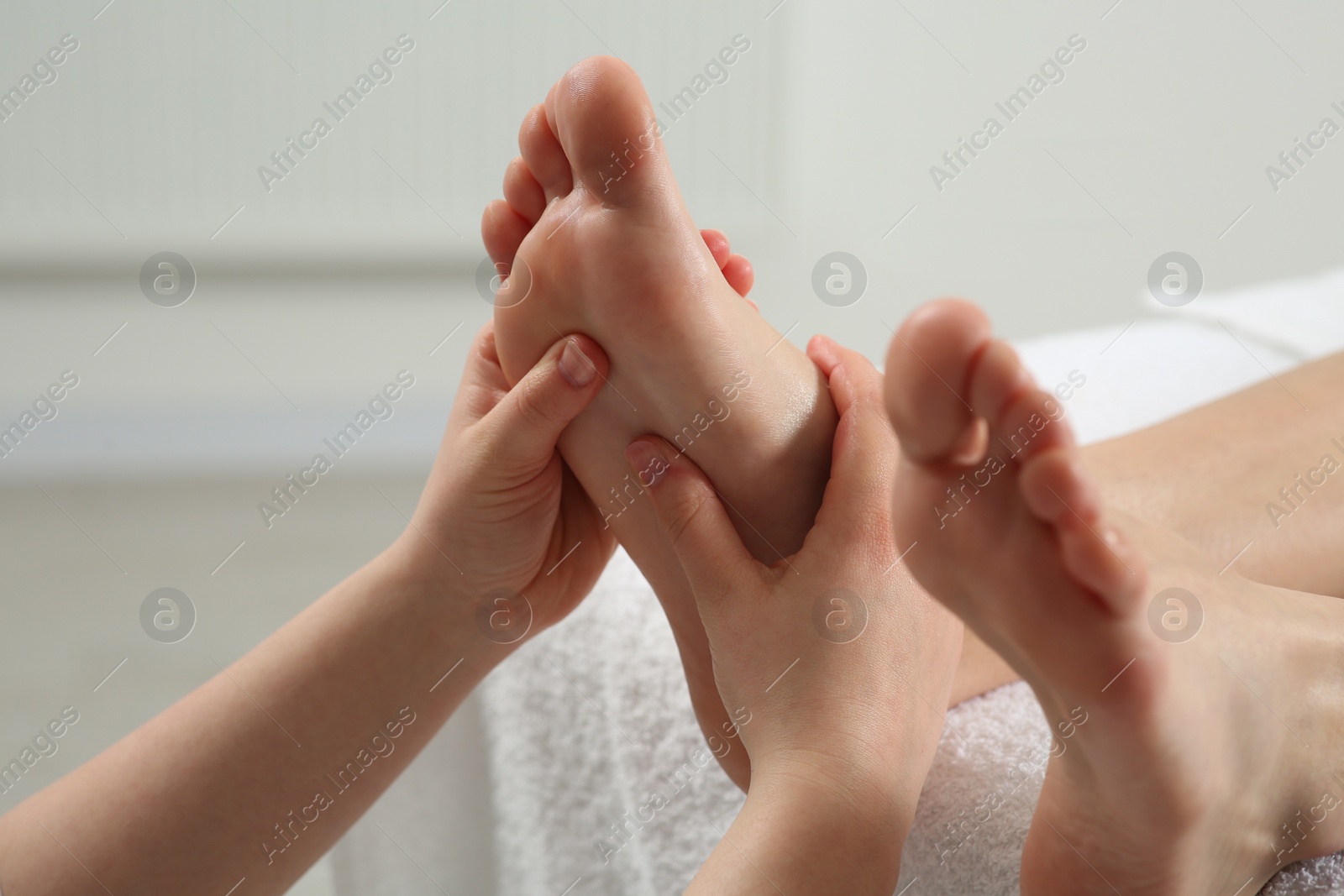 Photo of Woman receiving foot massage in spa salon, closeup