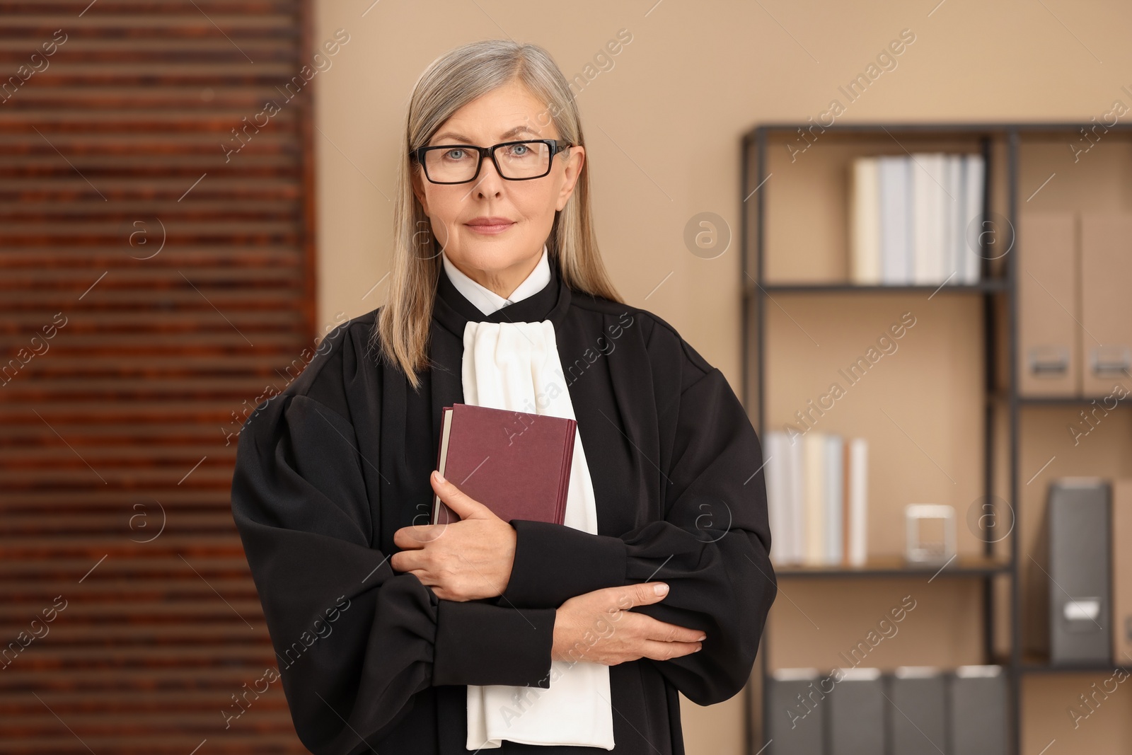 Photo of Portrait of judge in court dress with book indoors