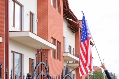 Photo of Woman with American flag near apartment building on city street