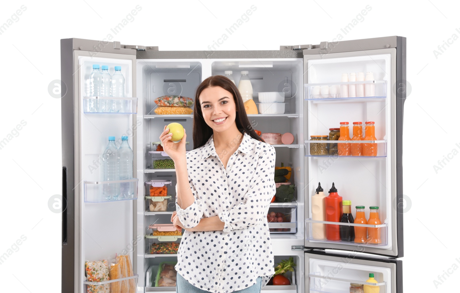 Photo of Young woman with apple near open refrigerator on white background