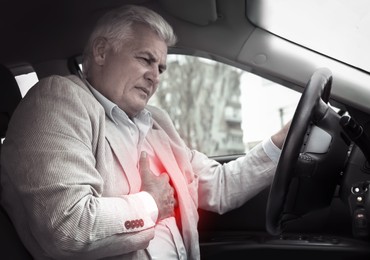 Image of Senior man having heart attack in car