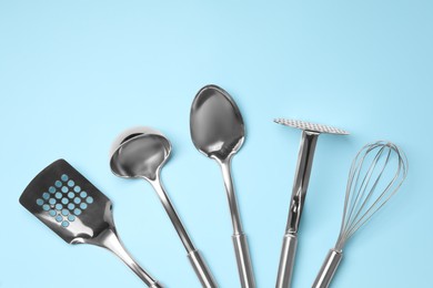 Photo of Set of modern cooking utensils on light blue background, flat lay