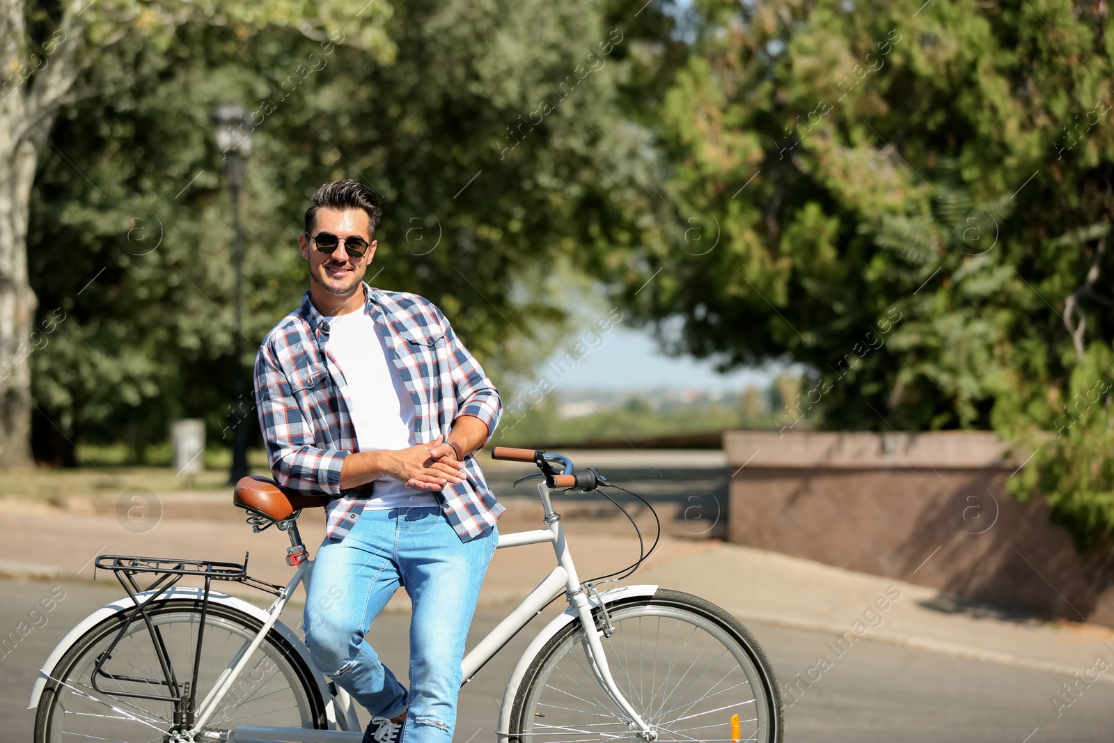 Photo of Handsome young hipster man with bicycle outdoors