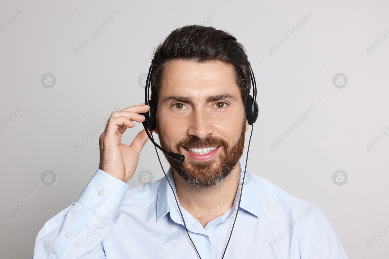 Photo of Hotline operator with headset on light grey background