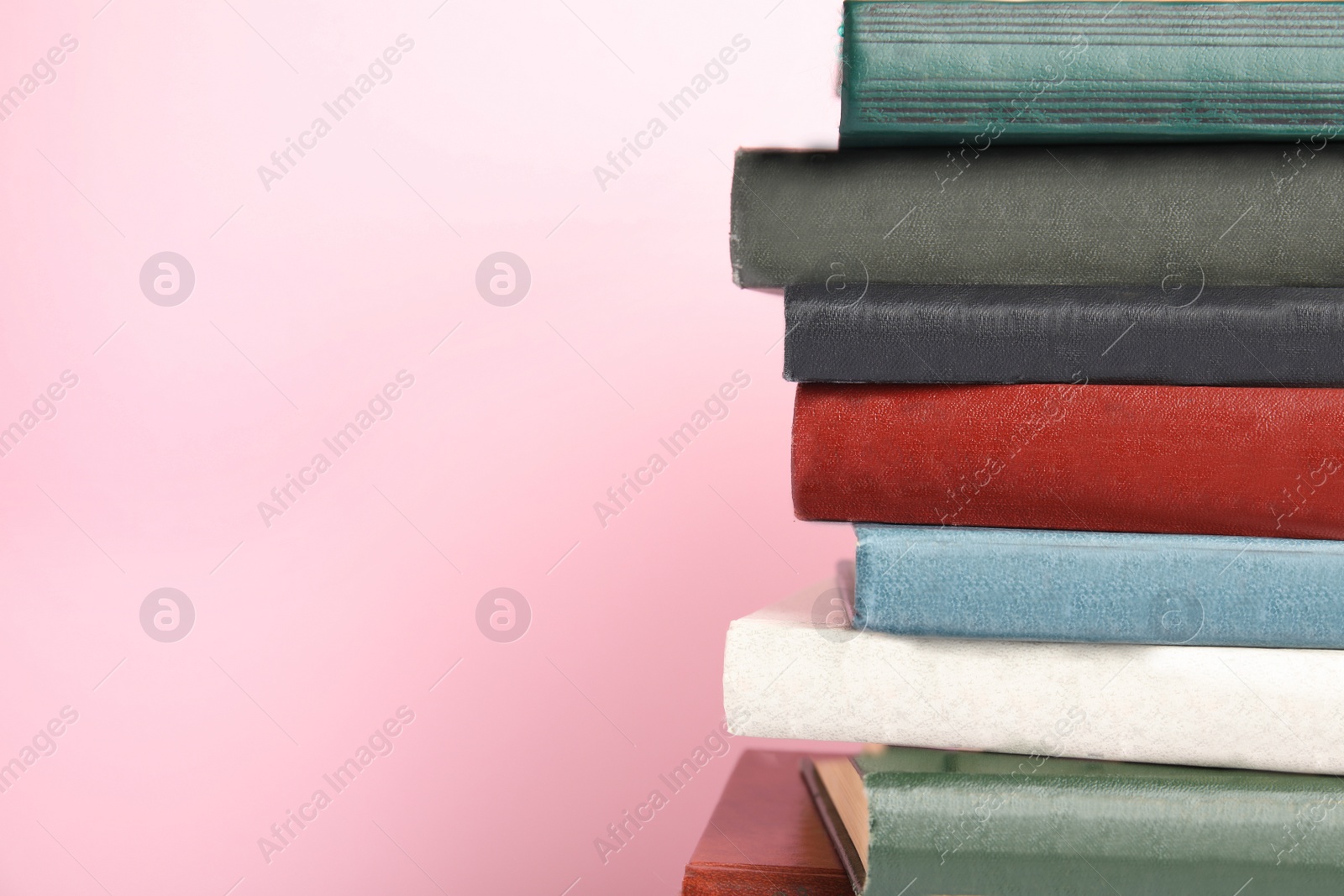 Photo of Collection of old books on pink background, space for text