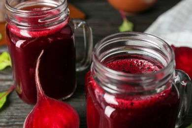 Photo of Fresh beet juice and raw vegetable on table, closeup