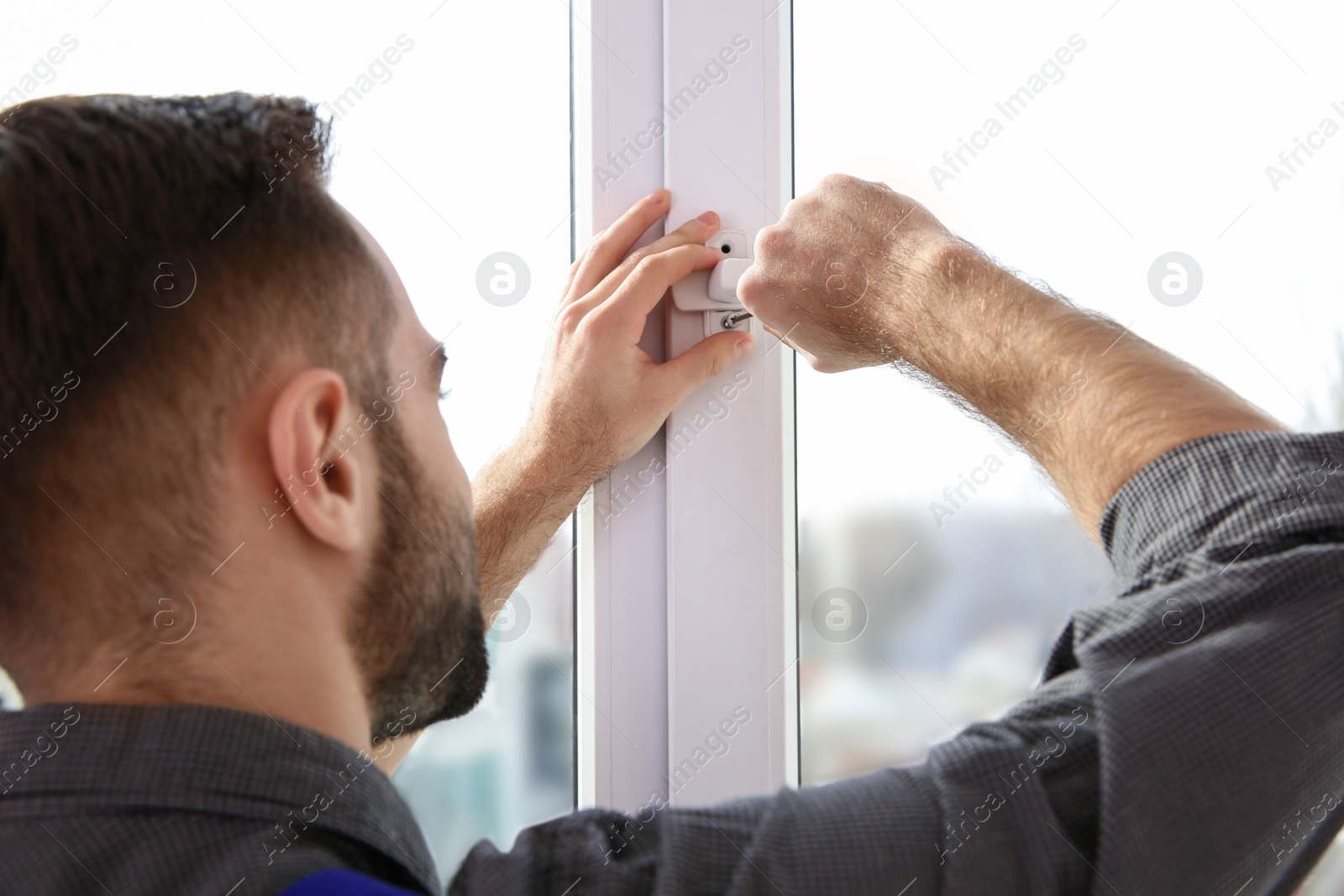 Photo of Professional construction worker installing window in apartment