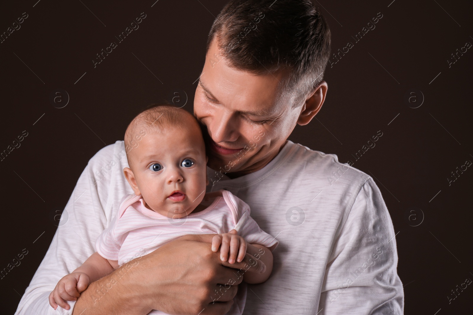 Photo of Happy father with his little baby on dark background