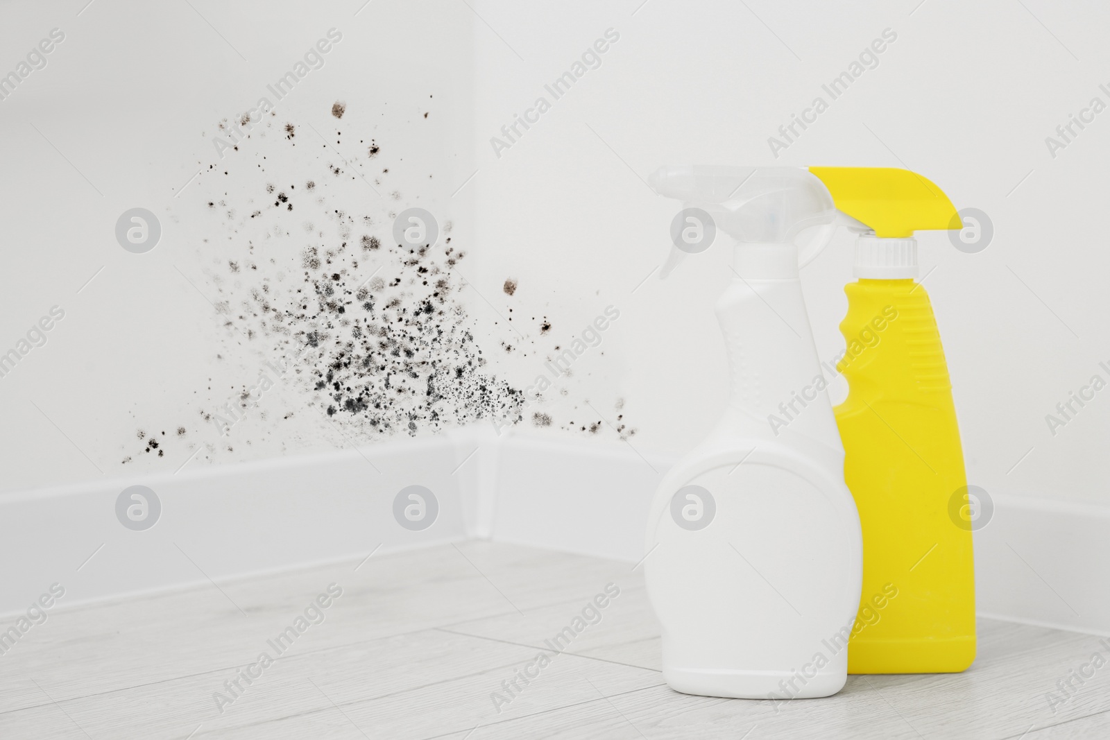 Image of Mold remover spray bottles on floor near affected walls in room