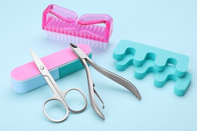 Photo of Set of pedicure tools on light blue background
