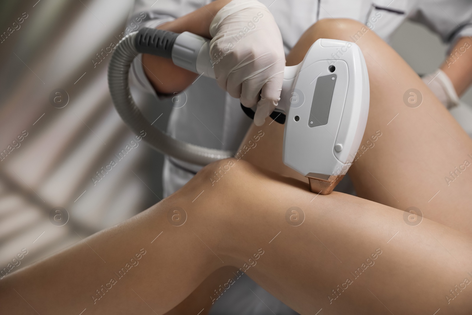 Photo of Woman undergoing laser epilation procedure in beauty salon, closeup