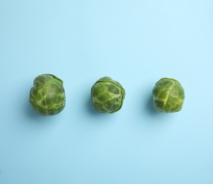 Photo of Fresh Brussels sprouts on light blue background, flat lay