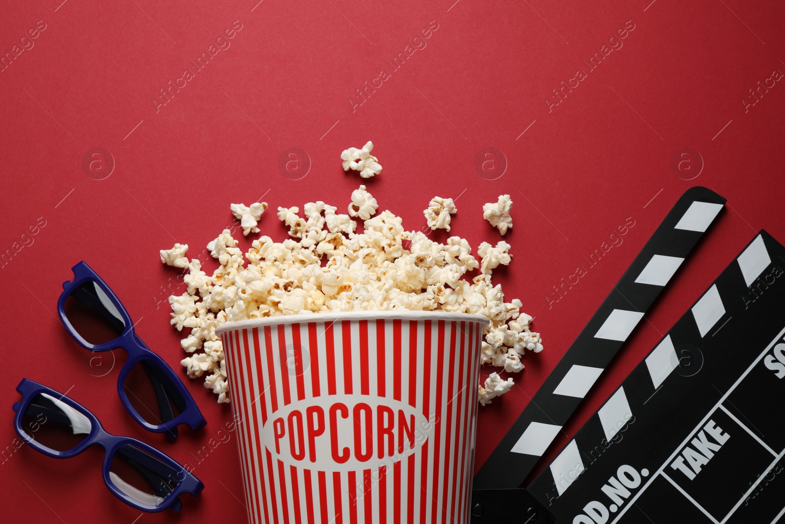 Photo of Flat lay composition with delicious popcorn on red background