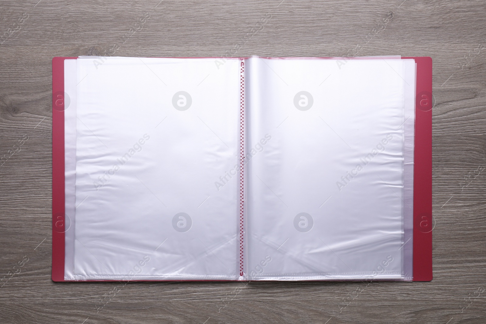 Photo of File folder with punched pockets on wooden table, top view