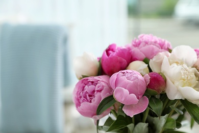 Photo of Bouquet of beautiful peonies in room, space for text