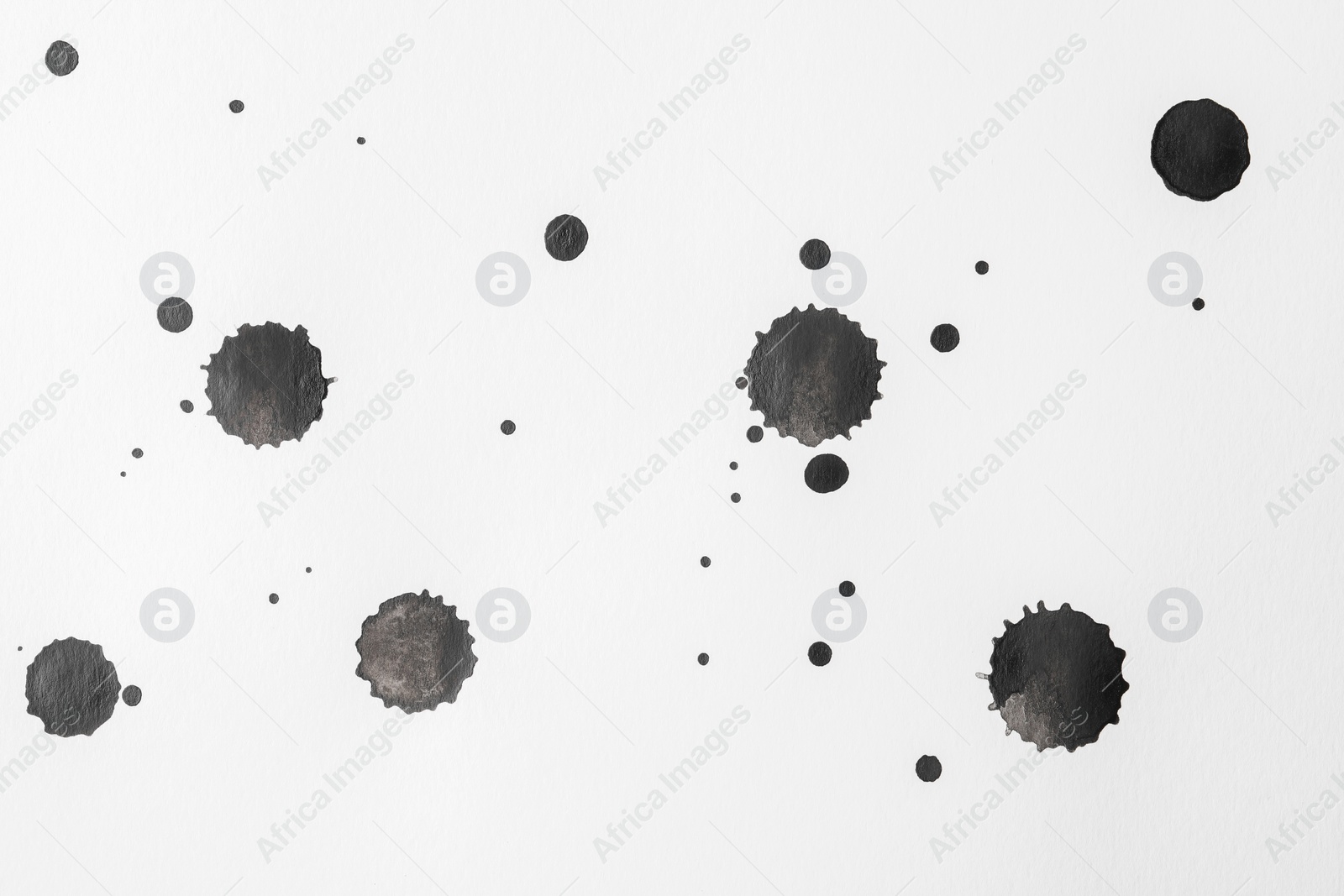 Photo of Blots of black ink on white background, flat lay