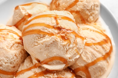 Photo of Tasty ice cream with caramel sauce, closeup