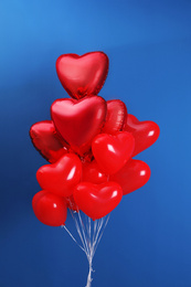 Photo of Bunch of heart shaped balloons on blue background. Valentine's day celebration
