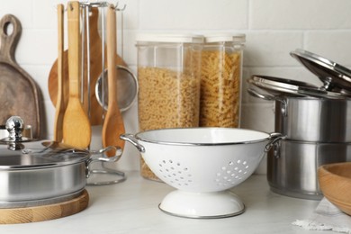 Photo of Different cooking utensils and raw pasta on countertop in kitchen