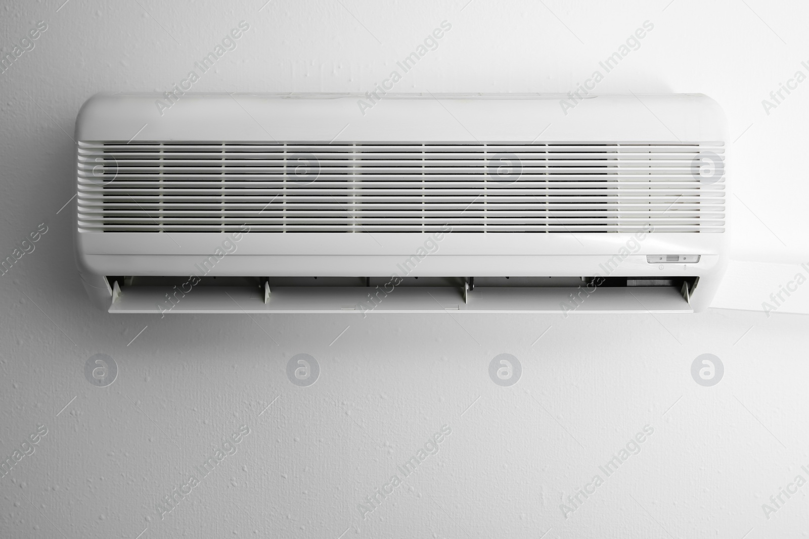 Photo of Modern air conditioner on white wall indoors