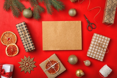 Photo of Flat lay composition with empty card and Christmas decoration on color background. Writing letter to Santa Claus