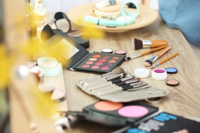 Photo of Decorative cosmetics and tools of professional makeup artist on table in salon