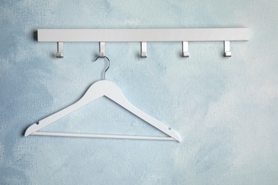 Photo of Rack with empty clothes hanger on color wall, space for text. Wardrobe accessory