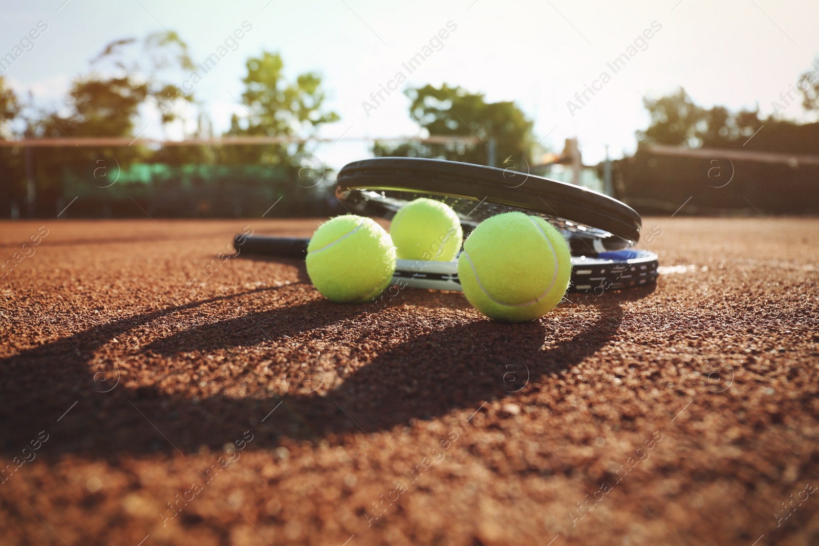 Photo of Tennis balls and rackets on clay court