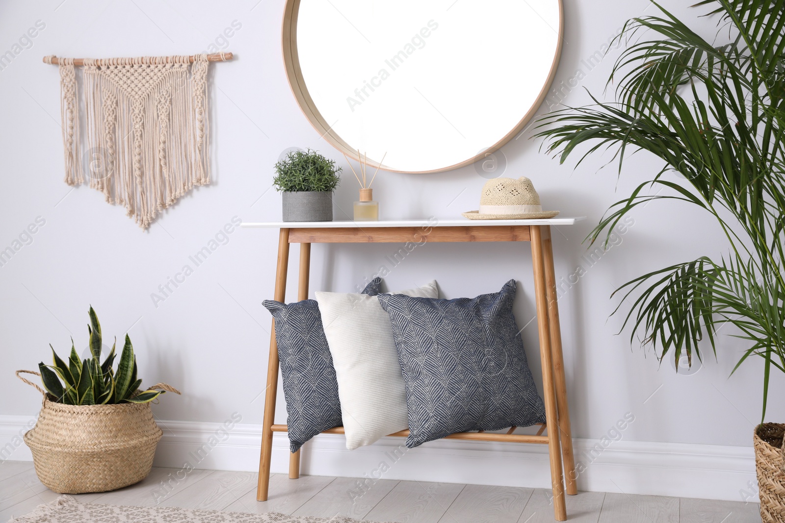 Photo of Round mirror and wooden table at home. Idea for interior design