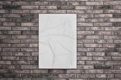Image of Blank creased poster on grey brick wall. Mockup for design 