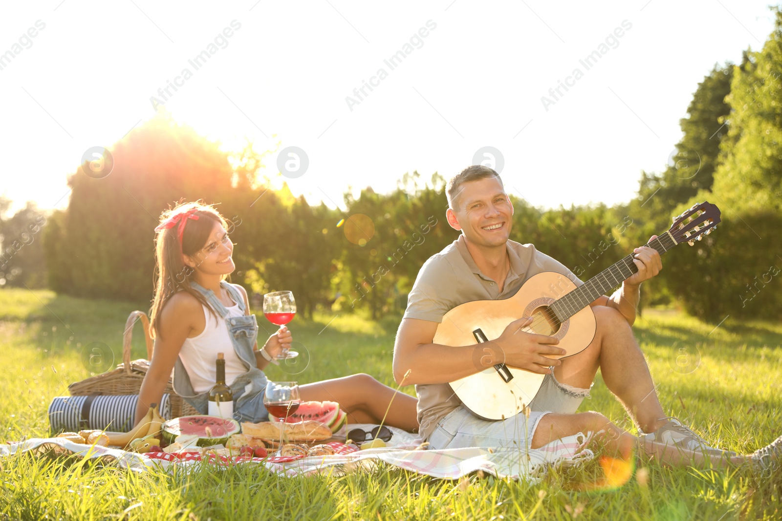 Photo of Happy couple with guitar on picnic in park