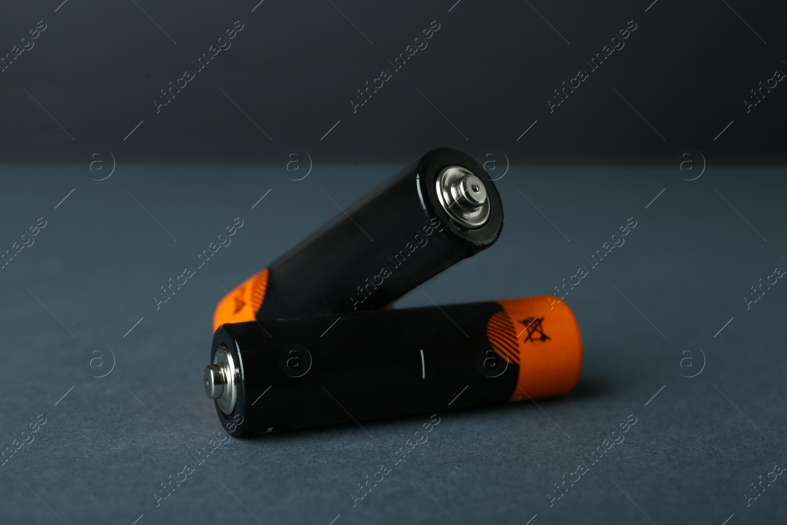 Image of Two new AA batteries on dark background, closeup