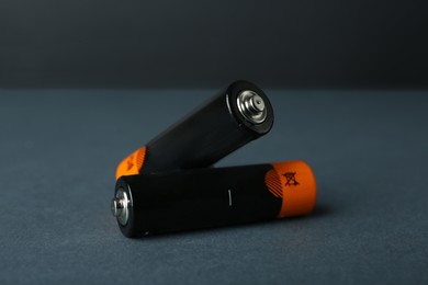 Image of Two new AA batteries on dark background, closeup