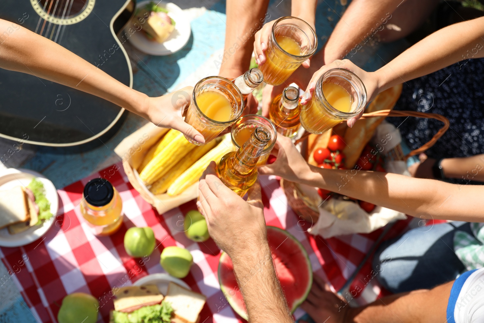 Photo of Young people enjoying picnic in park on summer day, top view