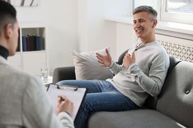 Photo of Professional psychotherapist working with patient in office