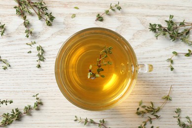 Photo of Aromatic herbal tea with thyme on white wooden table, flat lay
