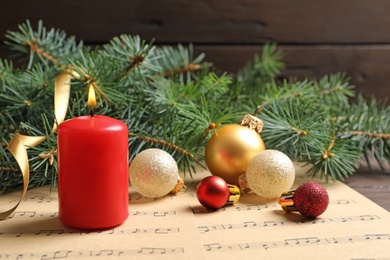 Photo of Composition with Christmas decorations and music sheets on table