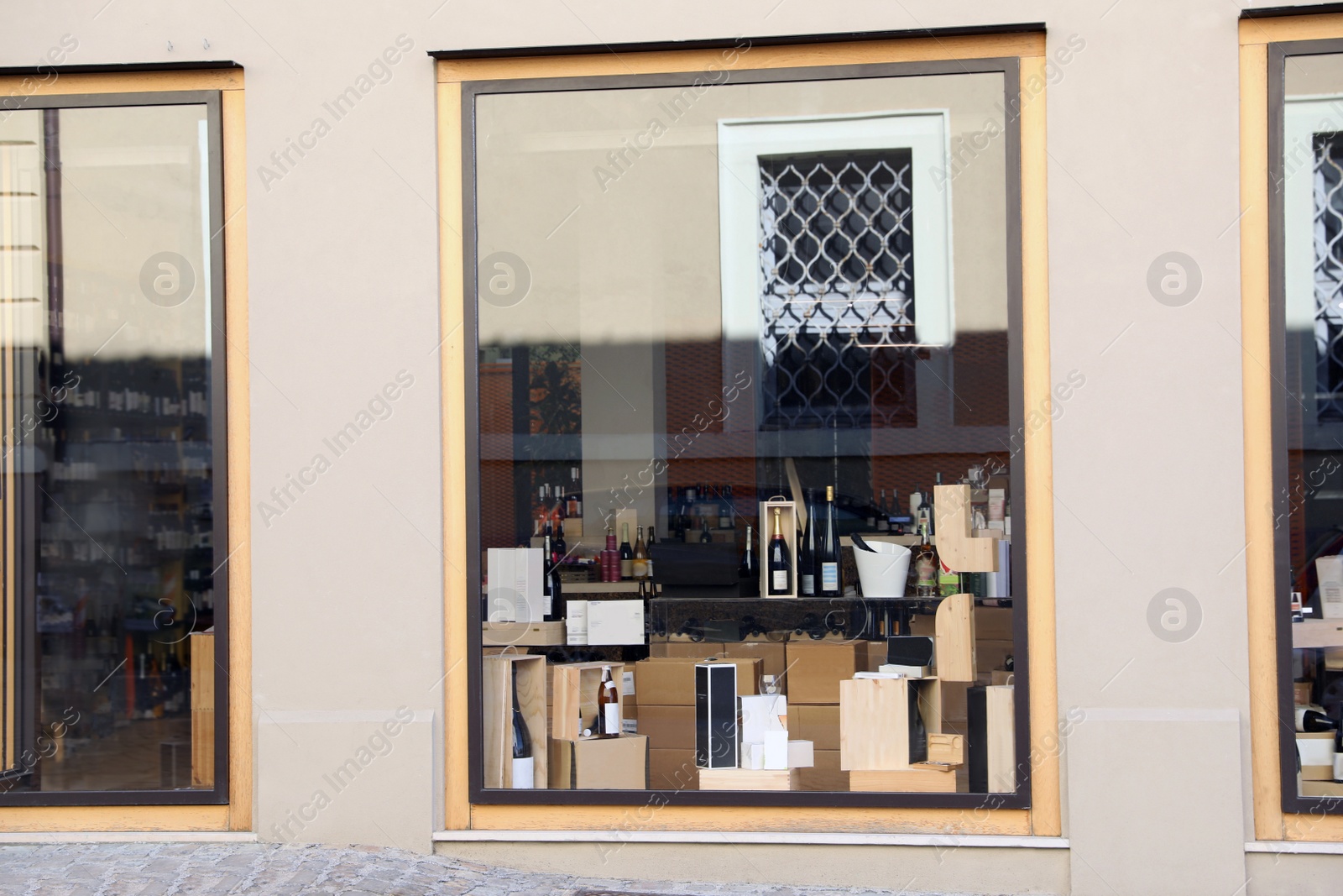 Photo of Bottles of different alcohol in wine shop, view through window