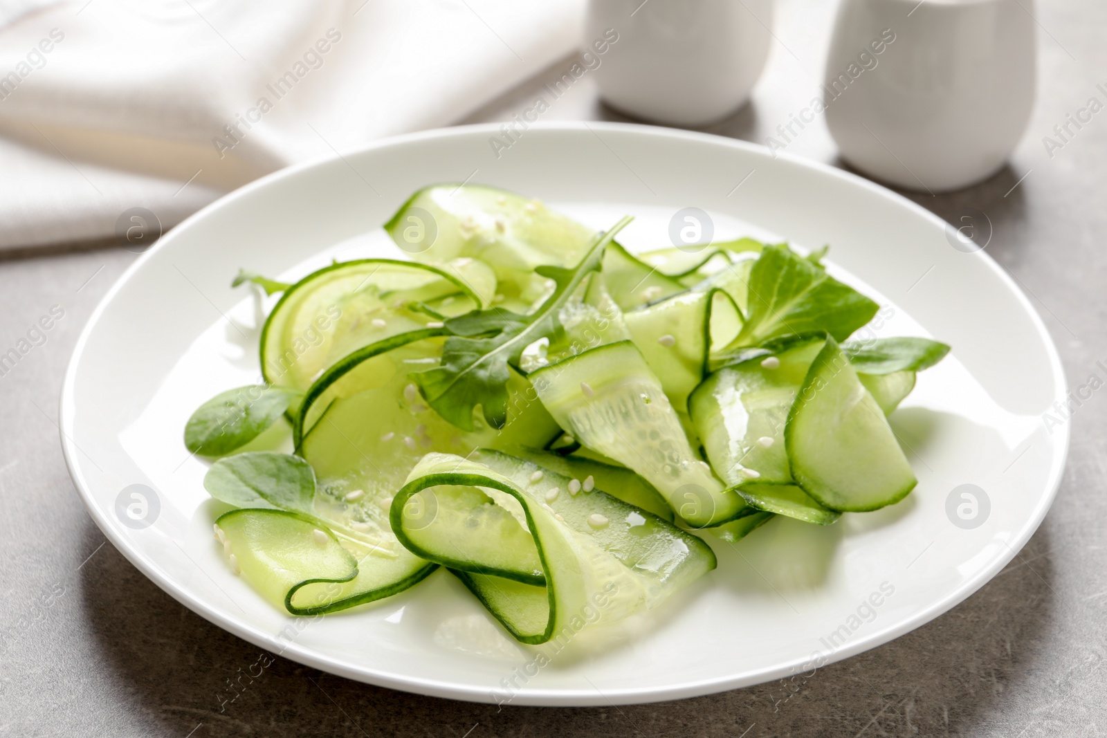 Photo of Plate with delicious cucumber salad on table, closeup