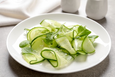 Photo of Plate with delicious cucumber salad on table, closeup