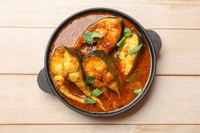 Photo of Tasty fish curry on white wooden table, top view. Indian cuisine