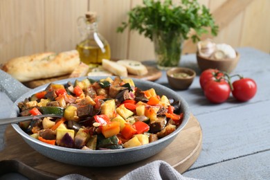 Delicious ratatouille in frying pan on grey wooden table, closeup. Space for text