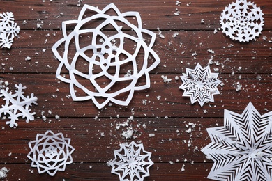 Flat lay composition with paper snowflakes on wooden background. Winter season