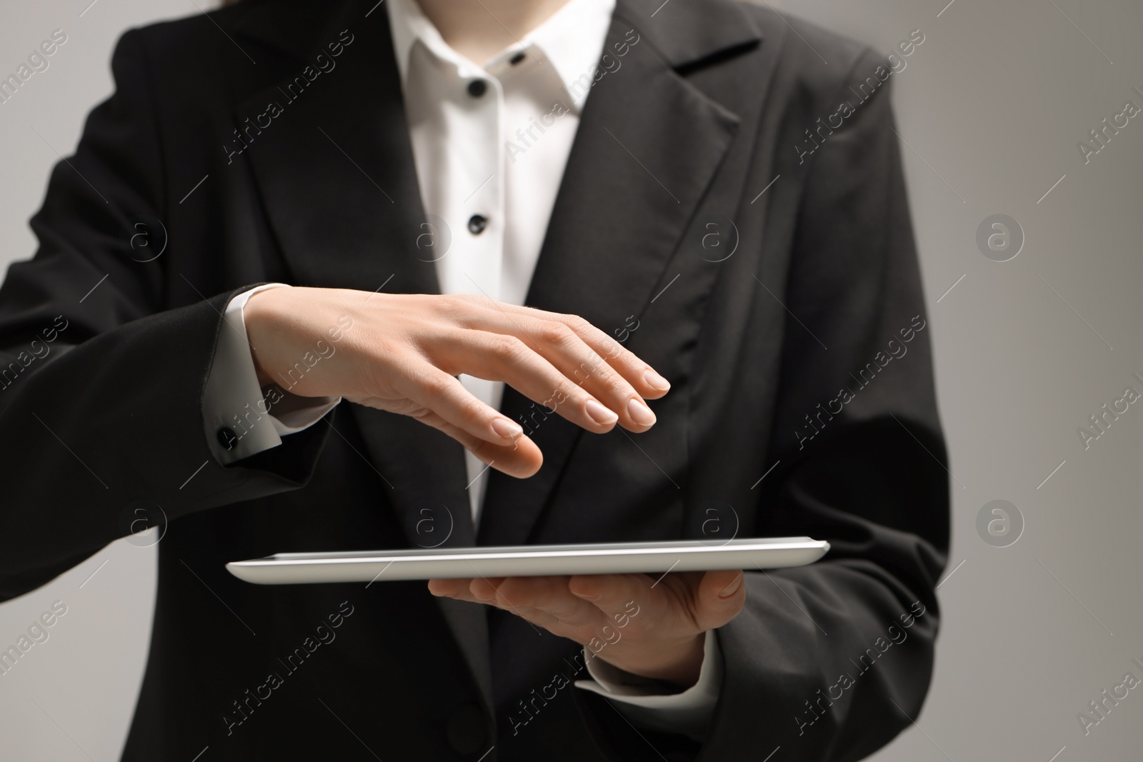 Photo of Closeup view of woman using modern tablet on grey background